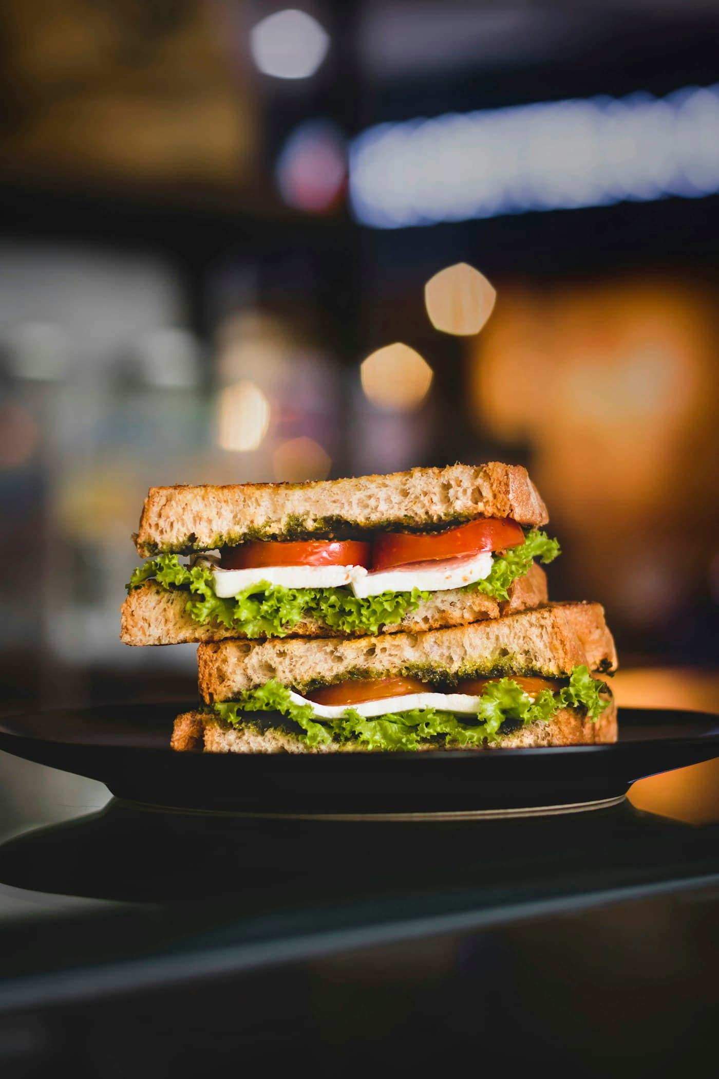 A club sandwich cut and stacked on a dark plate