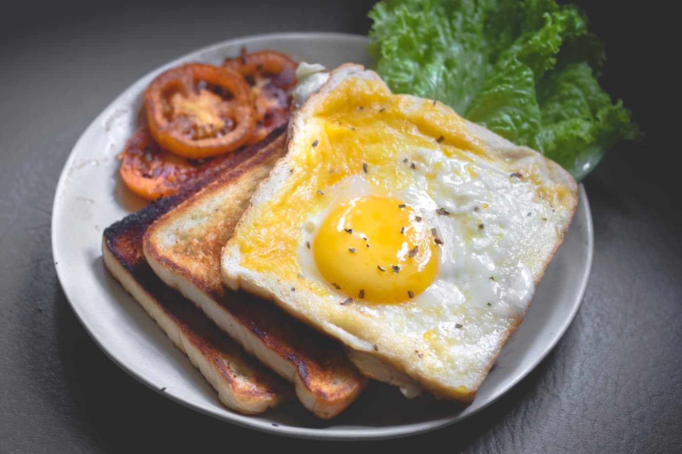 A breakfast plate with eggs, toast and roasted tomato