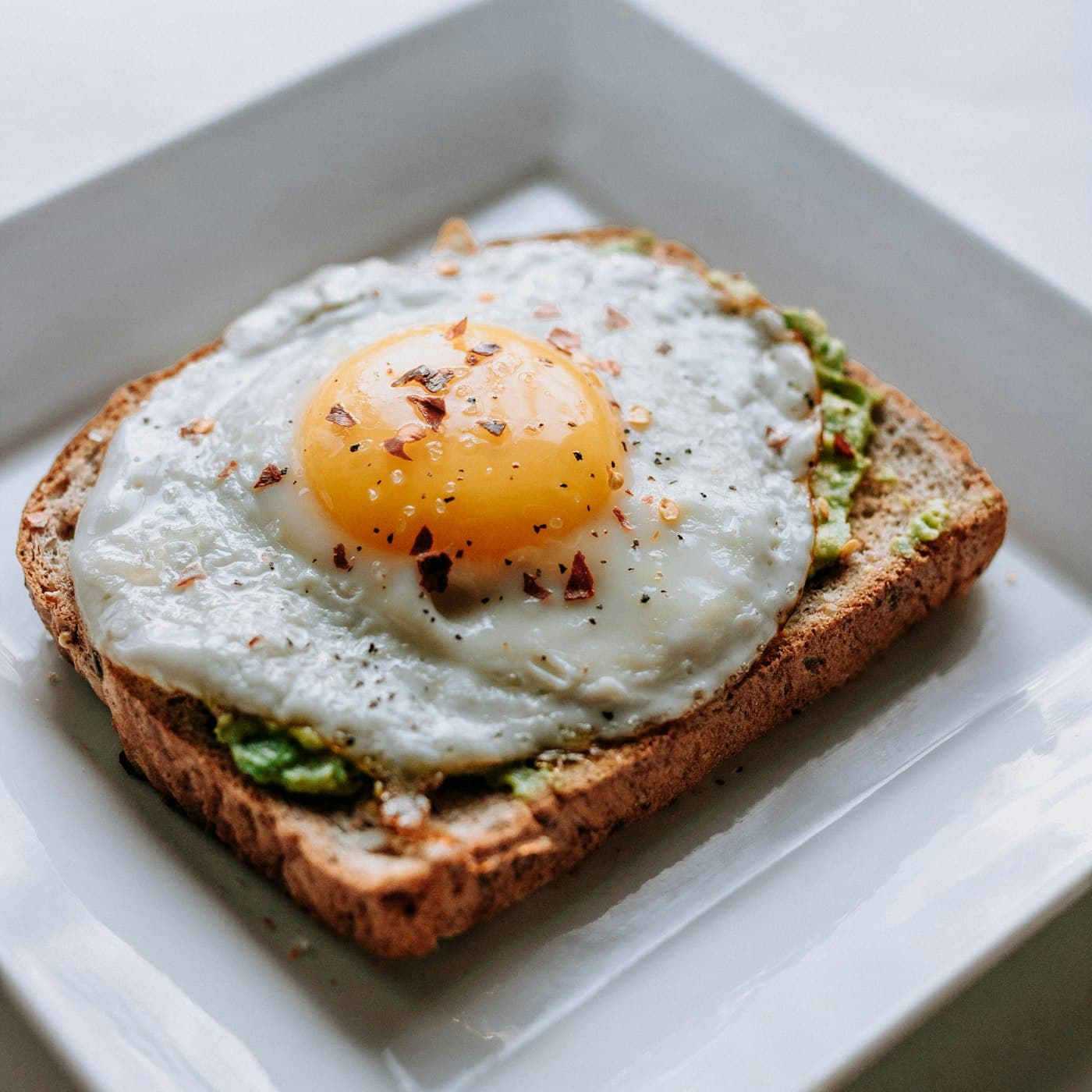 Avocado on toasted sourdough topped with a poached egg and chilli oil
